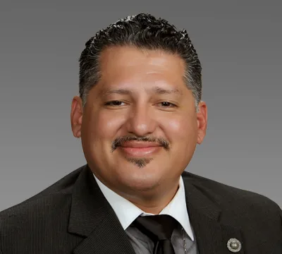 Rey León, professional portrait in a suit and tie.